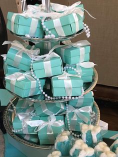 a tiered cake made out of blue and white boxes with bows on them, sitting on a table