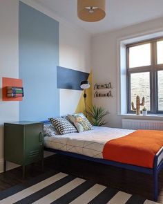 a bedroom with an orange and blue bed in it