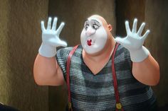 a man with his hands in the air while wearing a clown mask and suspenders