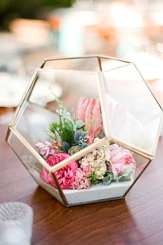 an image of a flower arrangement in a glass vase on a table with the caption'modern wedding centerpiece '