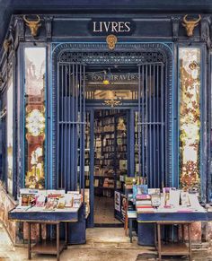 two tables with books on them in front of a book store door that is open