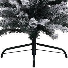 a black and white photo of a christmas tree on a stand with snow flakes