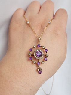 An absolutely stunning antique Victorian amethyst and seed pearl lavalier crafted in 9ct yellow gold. The chain is a delicate seed pearl rolo station chain measuring 16 inches in length. The pendant is modelled in a feminine circular shape with a dainty drop. It is both a pendant and a brooch. The pendant measures 4.8cm tall including bale and 2.5cm wide. The chain is original to the pendant. Combined, this necklace weighs 6.58g.  The seed pearl station chain is hallmarked 9ct while the pendant Purple Art Nouveau Jewelry Gift, Antique Round Purple Necklace, Victorian Purple Necklace For Anniversary, Victorian Hallmarked Purple Necklace, Victorian Style Hallmarked Purple Necklaces, Heirloom Purple Pendant Necklace, Purple Heirloom Pendant Necklace, Seed Pearl, Amethyst Stone