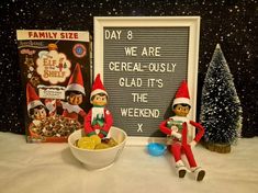 two elfs sitting in front of a chalkboard and cereal