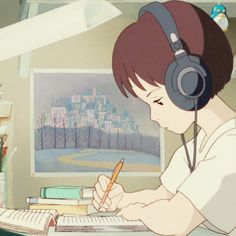 a person sitting at a desk with headphones on and writing in a book while holding a pen