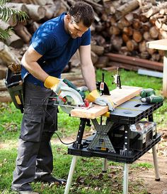 a man working on a table sawing wood in the yard with tools and equipment