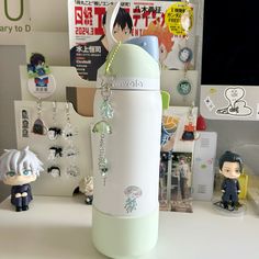 a white and green water bottle sitting on top of a desk next to figurines