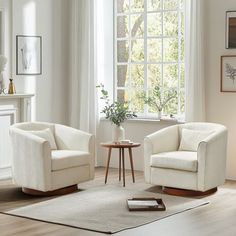 a living room with two chairs and a coffee table in front of a window,