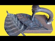 a metal object that is sitting on top of a yellow background with the words, how to make a leaf out of scrap metal