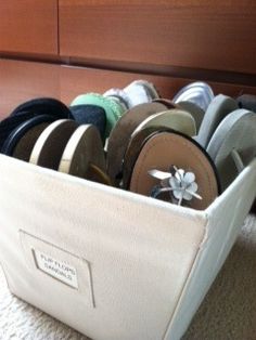 a white bin filled with lots of different types of thread and spools in it