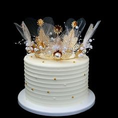 there is a white cake with gold decorations on top and pearls around the edges,