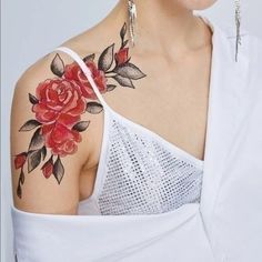 a woman with a rose tattoo on her arm and shoulder is wearing a white top