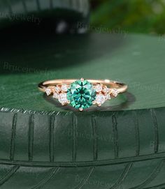 a close up of a green ring with diamonds on the top and bottom, sitting on a green surface