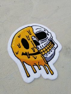 a yellow and black sticker with a skull on it