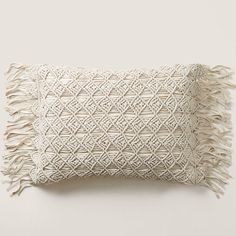 a white pillow with fringes on it