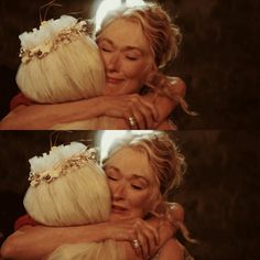 a woman with blonde hair hugging another woman's head