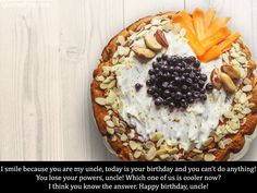 a cake with blueberries, almonds and other toppings sits on a white table