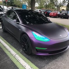 a purple tesla parked in a parking lot