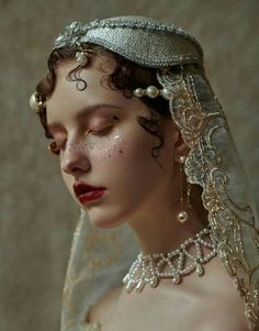 a woman wearing a veil and pearls on her head