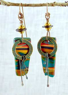 the earrings have been made with colorful glass and metal beads, hanging from a tree branch