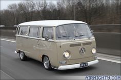 an old vw bus driving down the road