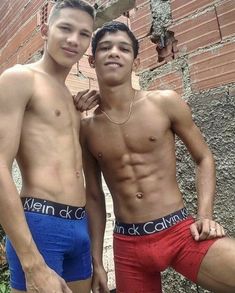 two young men standing next to each other in boxers and trunks with their arms around one another