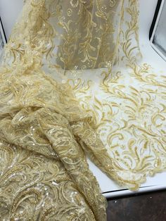 two pieces of gold sequinned fabric on display