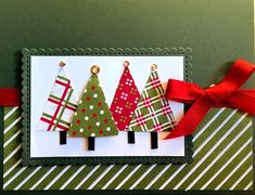 a christmas card with three small trees on it and a red ribbon around the edge