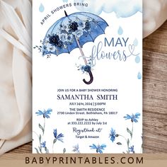 a baby shower is shown with blue flowers and an umbrella in the rain on it