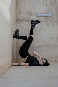 a woman is laying on the ground with her feet up in the air while wearing black shoes