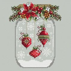 a cross stitch christmas ornament in a mason jar