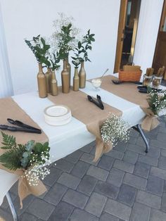 the table is set up with flowers and other items on it for an outdoor event