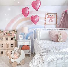 a child's bedroom decorated in pink and white with hearts flying above the bed