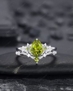 a yellow diamond ring sitting on top of a rock