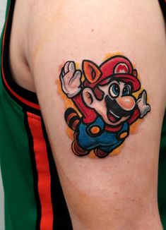 a mario tattoo on the back of a man's arm, with an image of luigi