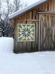 a barn in the snow with a quilt on it