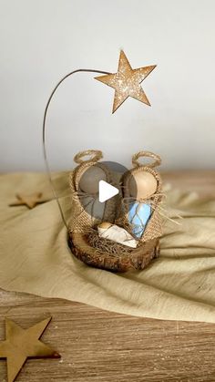 a glass nativity ornament with two baby shoes and a star