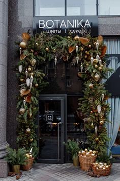 the entrance to botanika is decorated with greenery and gold ornaments on display