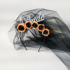 an umbrella with some black and orange flowers on it's side, in front of a white background