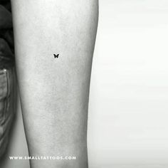 a black and white photo of a small butterfly tattoo on the right calf's leg