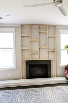 an empty living room with a fireplace and built in bookshelves