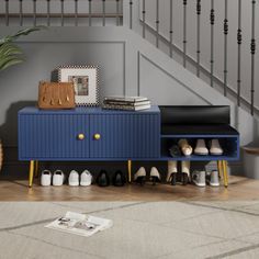 a blue cabinet with shoes on it next to stairs and a potted plant in the corner