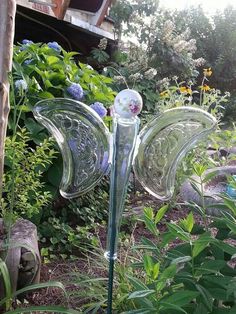 a glass sculpture in the middle of some plants