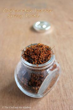 a jar filled with spices sitting on top of a wooden table