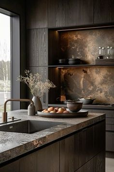 a modern kitchen with marble counter tops and dark wood cabinetry, along with an open window