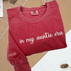 Celebrate your "Auntie Era" with our Comfort Colors® embroidered sweatshirt! This cool aunt sweatshirt, personalized with kids' names, makes the perfect birthday gift for the amazing aunts in your life. Join the Cool Aunts Club in style! PRODUCT AND BRAND DETAILS ➤ Comfort color ® brand ➤ Unisex & Classic fit Material: 9.5 oz., 80% ring spun USA cotton, 20% polyester Preshrunk, soft-washed, garment-dyed fabric Made with 80% sustainably and fairly grown USA cotton and sewn with USA cotton thread PERSONALIZED GUIDE: Custom sweatshirts, hoodies, and tees will usually have four embroidery positions: ➤On the chest: Left chest (above the heart), right chest, middle chest. ➤On the sleeve: Left sleeve or right sleeve (you can customize both, one side is free). ➤On the back of the shirt: In the mid Custom Embroidered Crew Neck Top For Birthday, Custom Embroidery Crew Neck Top For Birthday, Long Sleeve Tops With Letter Embroidery For Birthday, Long Sleeve Cotton Sweatshirt For Anniversary, Birthday Gift For Aunt, Auntie Era, Aunt Sweatshirt, Aunt Birthday Gift, Cool Aunt