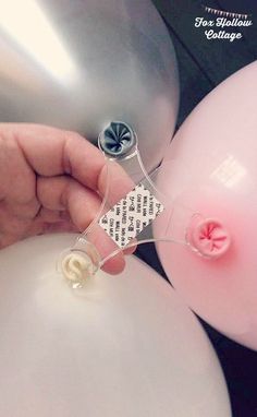 a person is holding some balloons in front of a metal container with buttons on it