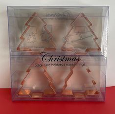 three pieces of glass in a box with christmas decorations on them and the words, place card holders - napkin rings