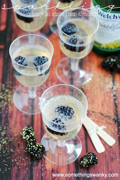 three glasses filled with white wine and blackberries