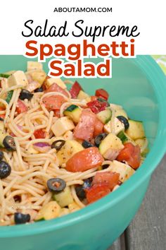 a green bowl filled with pasta and veggies on top of a wooden table